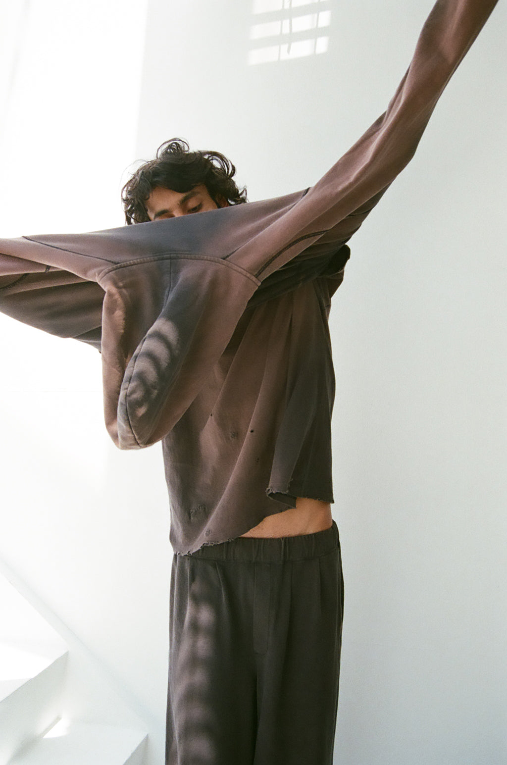 concause W-V AFTER HOODIE ルックスタイリング / BLACK 男性モデル 白壁前 フードを脱すアクションビュー
