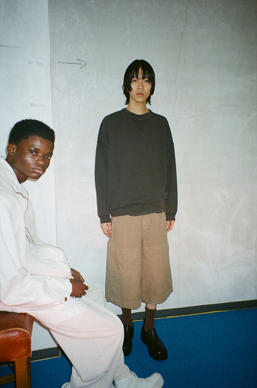 concause CORDUROY LUNCH PANTS ルックスタイリング / TAUPE 2人コーディネート 白壁前 立ちビュー

