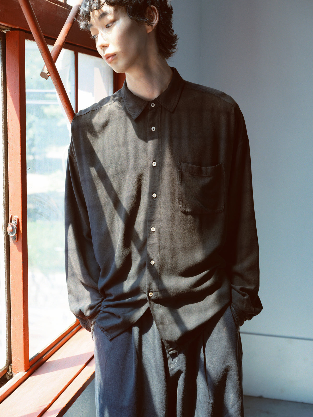 concause｜2026 S/S コレクション｜メンズ モデル 上半身 窓際 着用｜ブラック シアーシャツ
