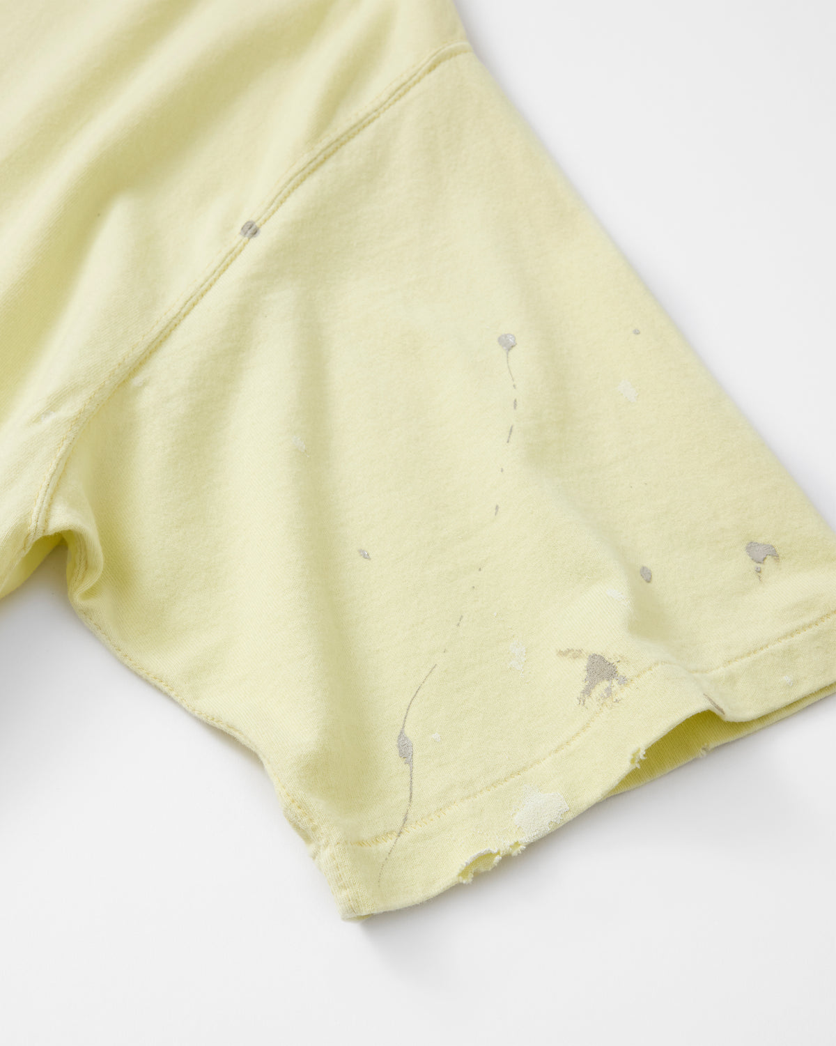 concause S/S TEE / YELLOW クルーネックとブランドタグのディテール
