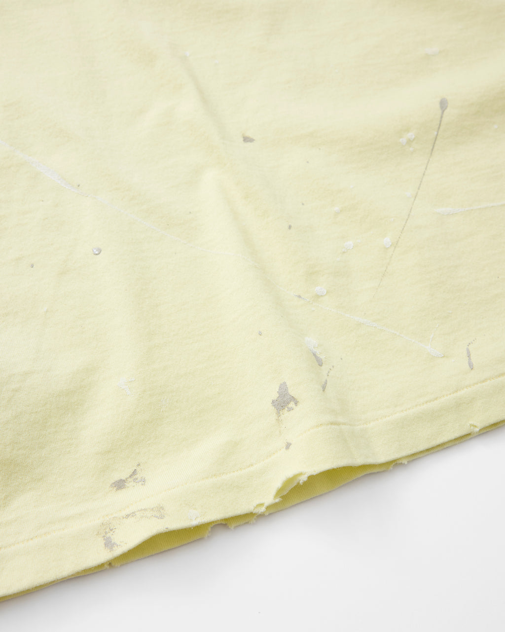 concause S/S TEE / YELLOW 裾口のペンキ飛び加工と裁ち切り仕上げディテール
