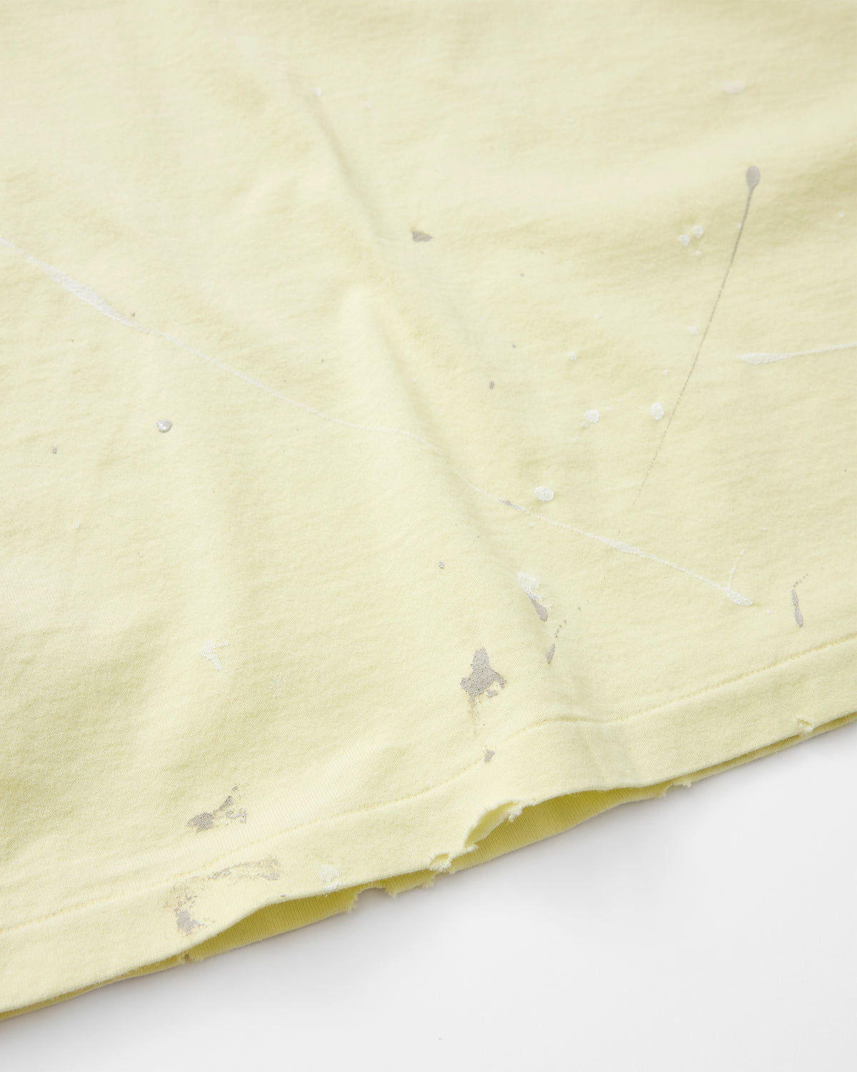 concause S/S TEE / YELLOW 裾口のペンキ飛び加工と裁ち切り仕上げディテール
