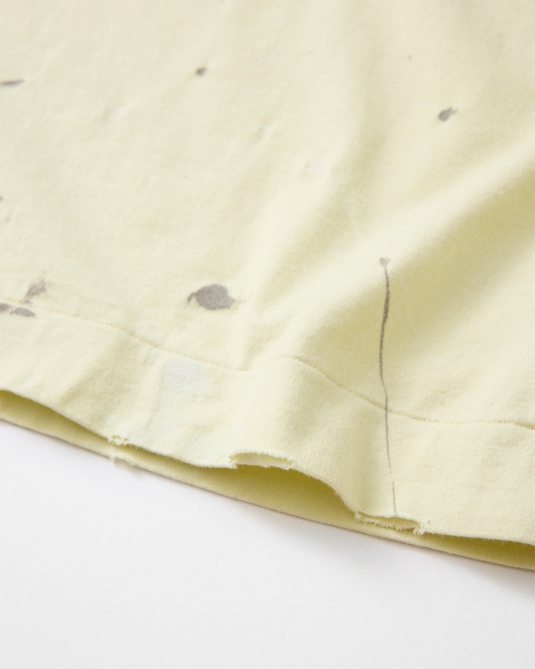 concause LITTLE S/S TEE / YELLOW 裾のペンキ飛び加工と裁ち切り仕上げディテール（2）

