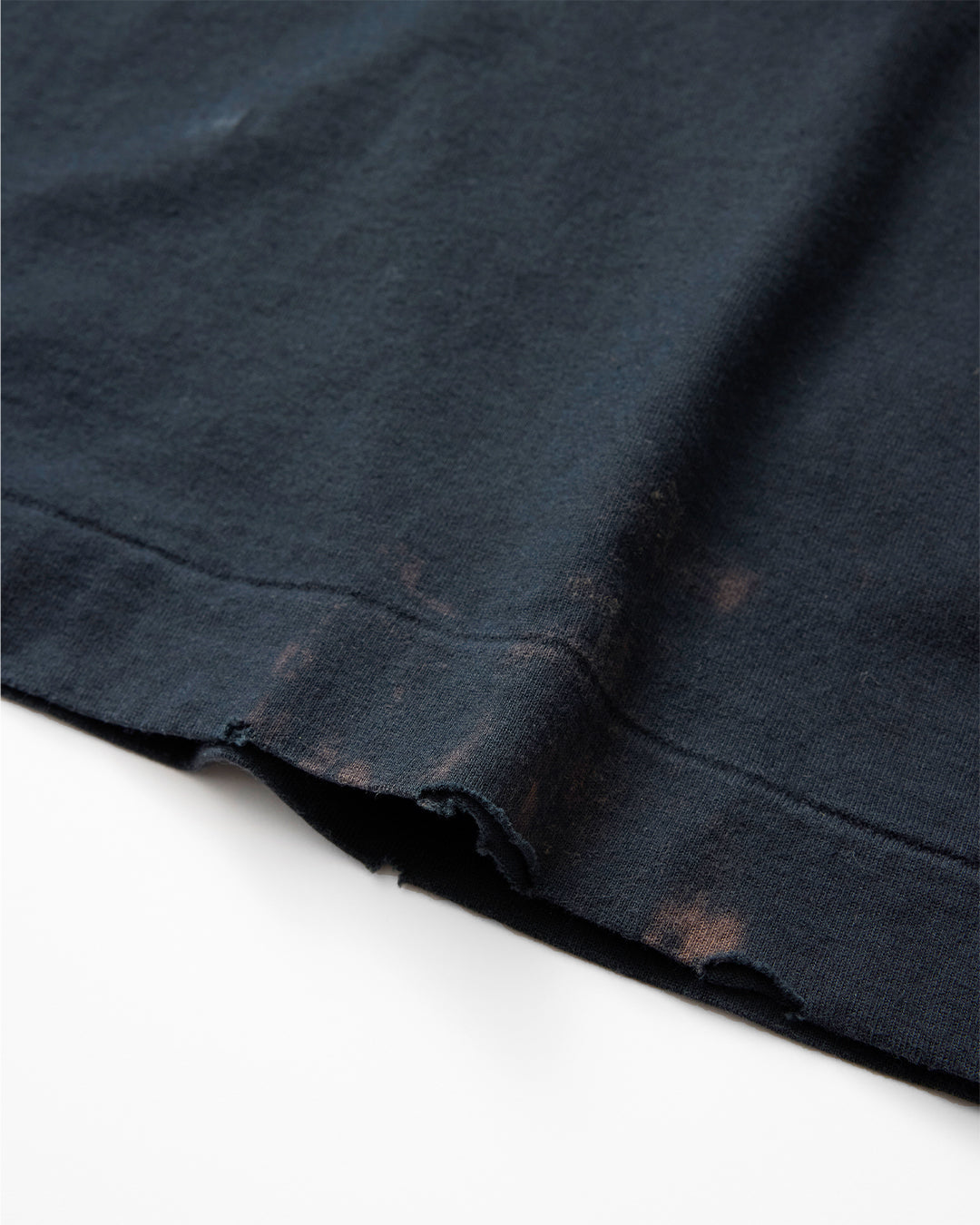 concause LITTLE S/S TEE / BLACK 裾のペンキ飛び加工と裁ち切りディテール
