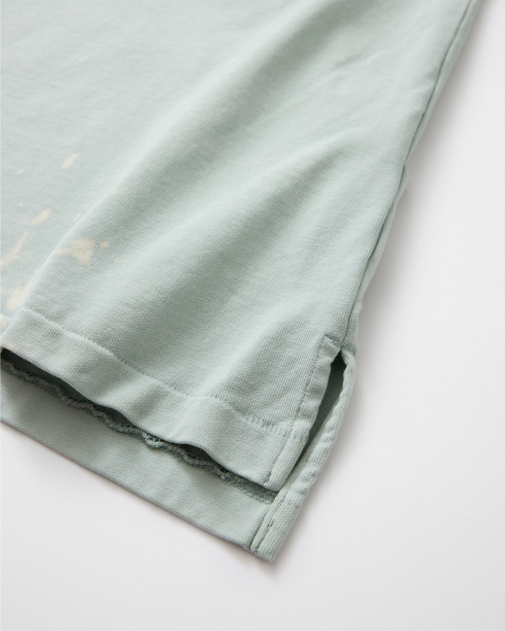 concause MOCK NECK S/S TEE / GREEN 裾のペンキ飛び加工と裁ち切り仕上げディテール
